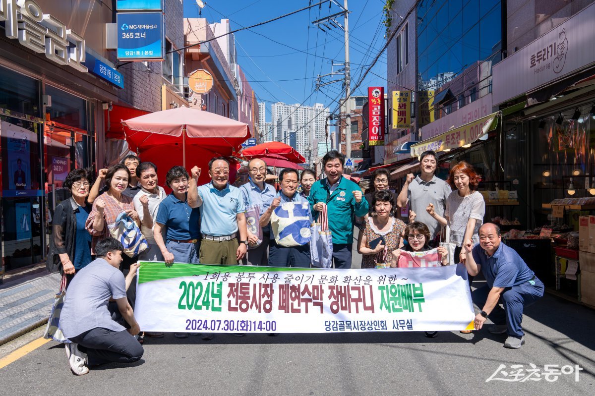 부산 부산진구가 지난 30일 폐현수막을 재활용해 만든 장바구니 2000개를 당감새시장·당감골목시장 상인회에 전달한 가운데 관계자들이 기념촬영을 하고 있다. (사진제공=부산 부산진구)