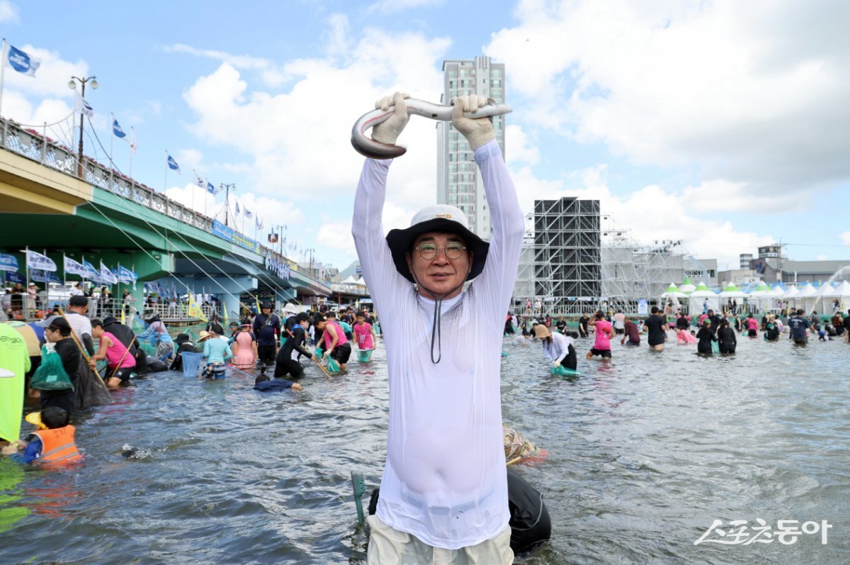 제17회 정남진 물축제에서 고기를 잡고 있는 김성 장흥군수. 사진제공=장흥군