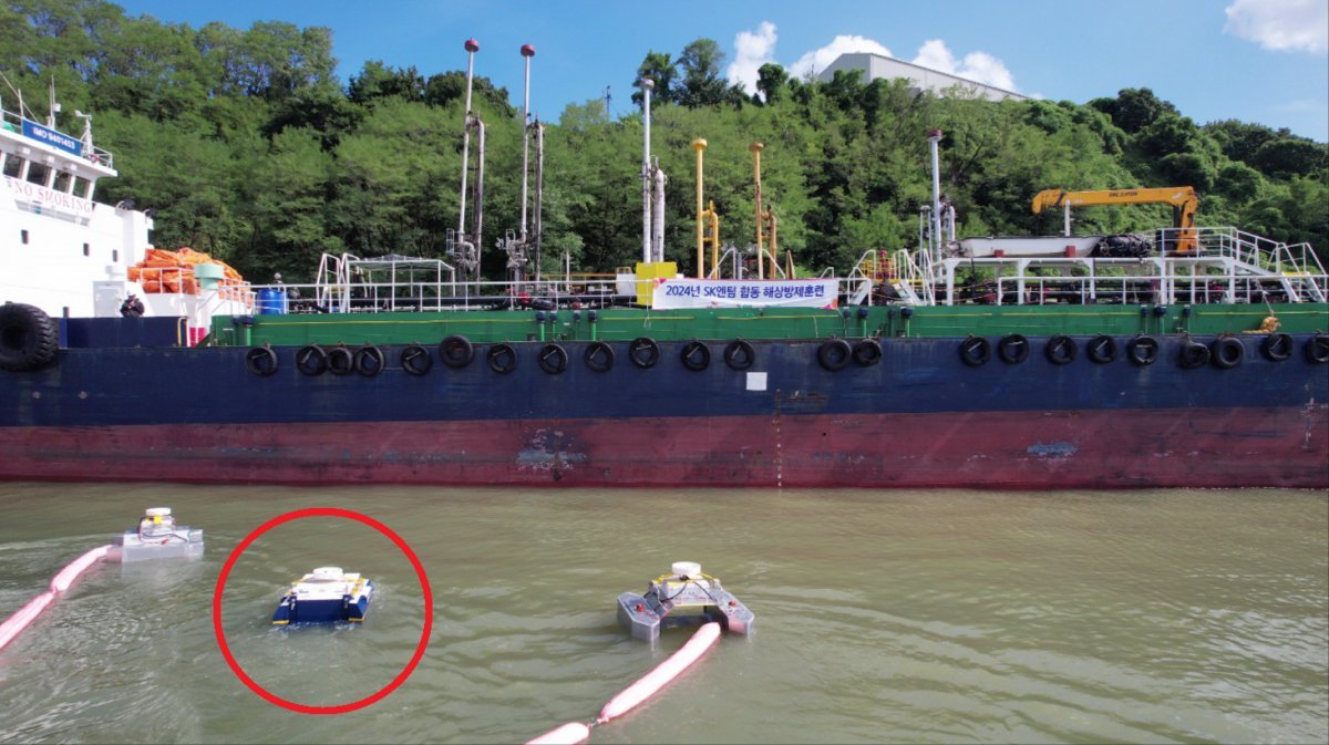 SK이노베이션이 투자한 스타트업 쉐코의 유회수기 방제로봇 ‘아크-M’(빨간색 원으로 표시)이 20일 SK이노베이션 울산Complex(이하 울산CLX) 인근 SK부두에서 해상 방제훈련을 실시하고 있다. 사진제공 ｜SK이노베이션