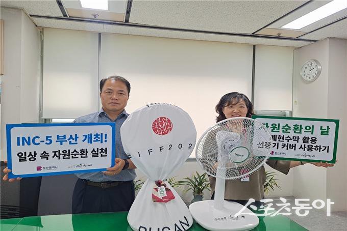 부산시 관계자들이 폐현수막 활용 선풍기 덮개 사용 캠페인을 홍보하고자 기념촬영을 하고 있다. (사진제공=부산시)