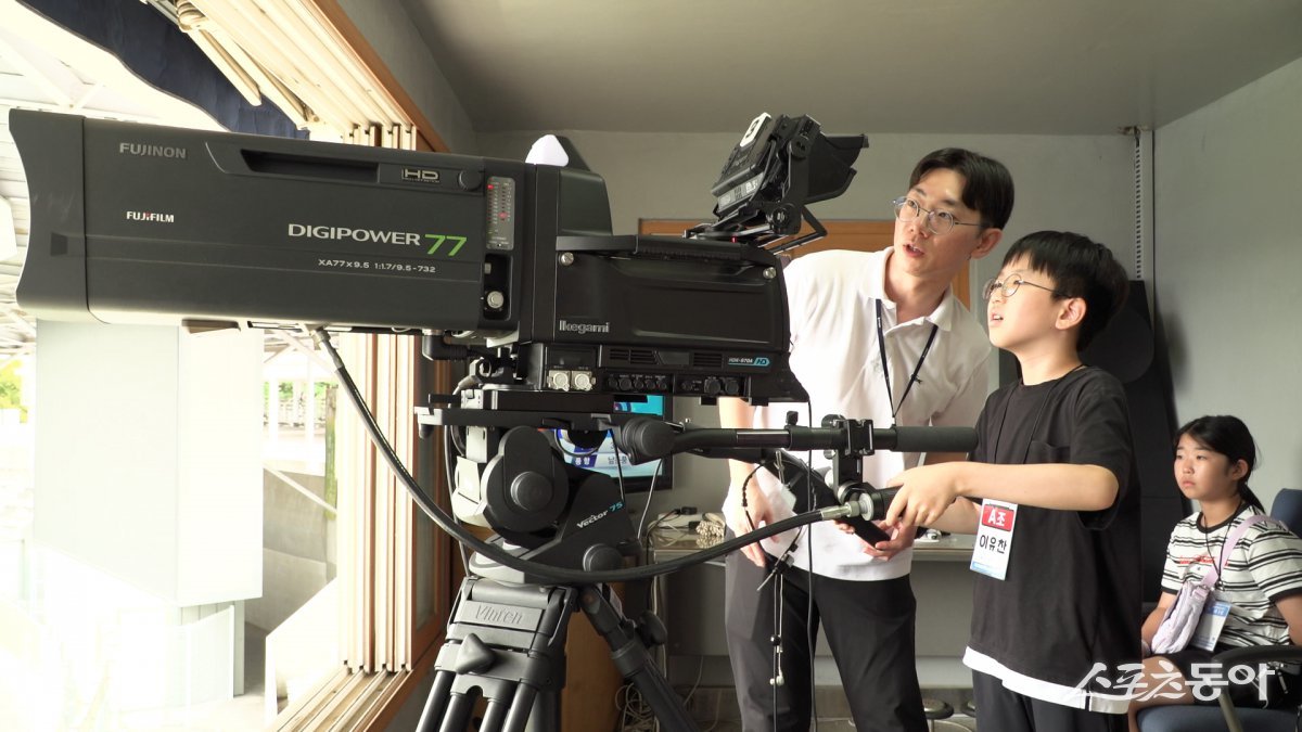 부산시설공단이 지난 21일 스포원파크 내 경륜장에서 직원 재능기부 방송 직업체험 교실을 진행한 가운데 한 어린이가 스포츠 중계용 카메라 실습을 하는 모습. (사진제공=부산시설공단)