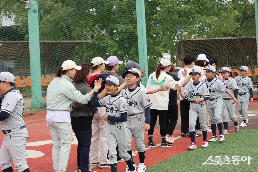 일산동구 리틀야구단에서 운영하는 ‘학부모 경기 참여 이벤트’에서 리틀 야구단 학생들과 학부모님들이 페어플레이를 다짐하며 하이파이브를 하고 있다.   사진 | 우지우