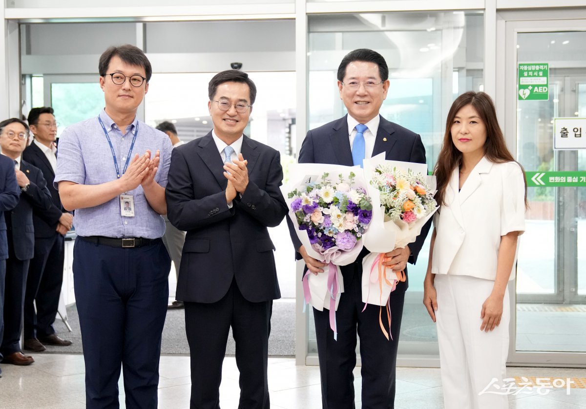 23일 ‘1일 명예 경기도지사직’을 수행하기 위해 경기도청을 방문한 김영록 전라남도지사가 경기도청 직원들의 환영을 받으며 꽃다발을 전달받고 기념촬영을 하고 있다. 사진제공=전남도