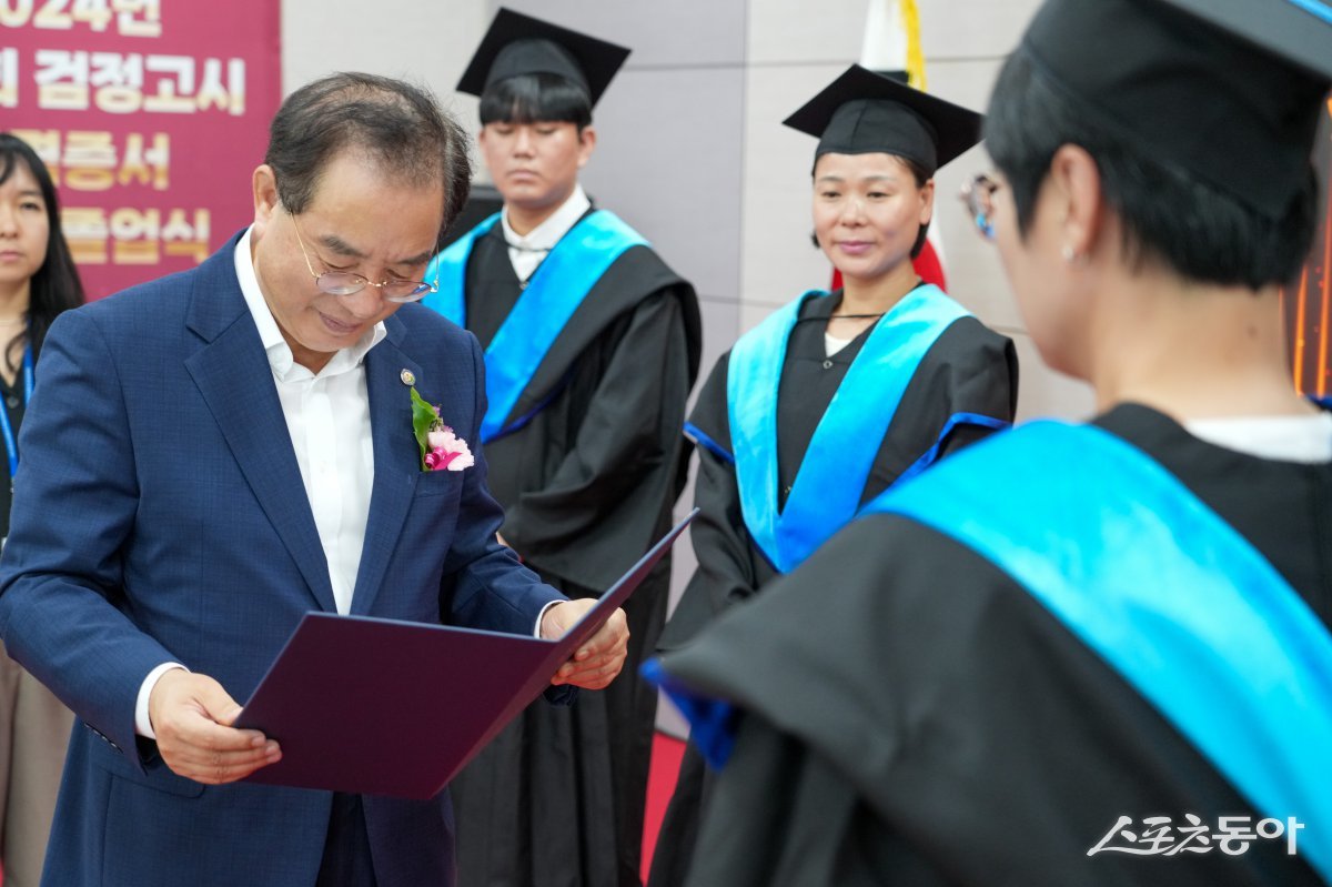 하윤수 교육감(왼쪽)이 지난 9일 시교육청 별관 국제회의실에서 열린 ‘2024년도 제2회 검정고시 합격증서 수여식’에 참석해 합격자에게 합격증서를 수여하고 있다. (사진제공=부산시교육청)