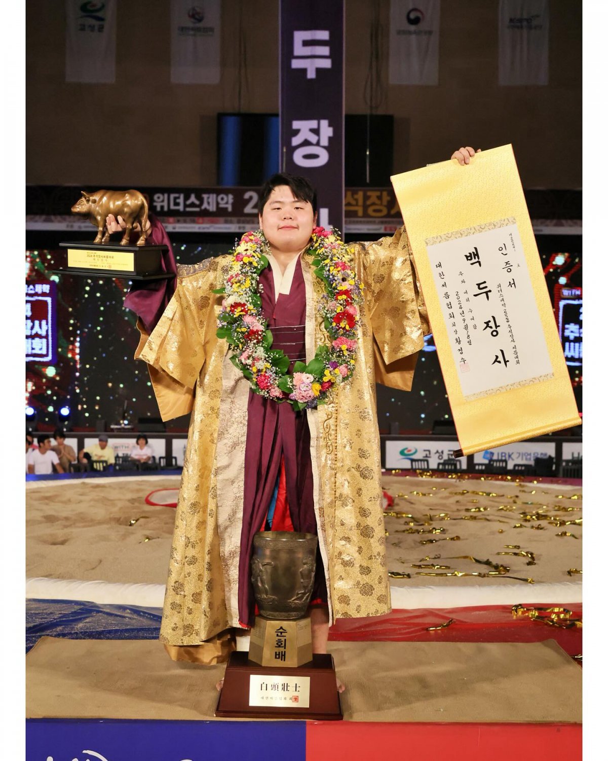 김민재가 18일 경남 고성군 고성군국민체육센터에서 열린 ‘위더스제약 2024 추석장사씨름대회’ 백두장사에 오른 뒤 인증서와 황소트로피를 들로 포즈를 취하고 있다.  사진출처 ㅣ 대한씨름협회 SNS