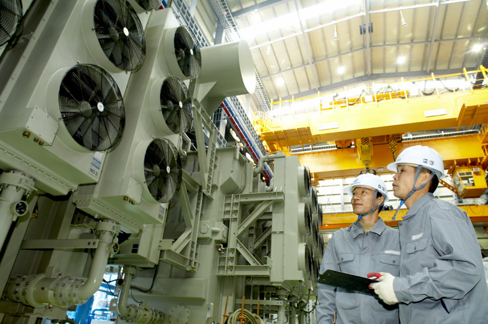 효성중공업이 전력기기 시장 호황으로 안정적 실적을 기록하며 순항 중이다. 자사 초고압변압기(위)와 이를 점검하고 있는 직원들. 사진제공｜효성중공업