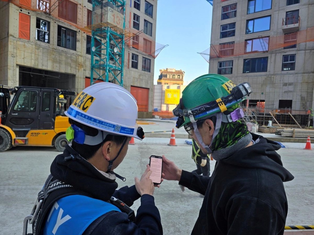 DL이앤씨 직원이 수도권의 한 아파트 건설 현장에서 외국인 노동자에게 ‘AI 자동번역 시스템’을 안내하고 있다. 사진제공 | DL이앤씨