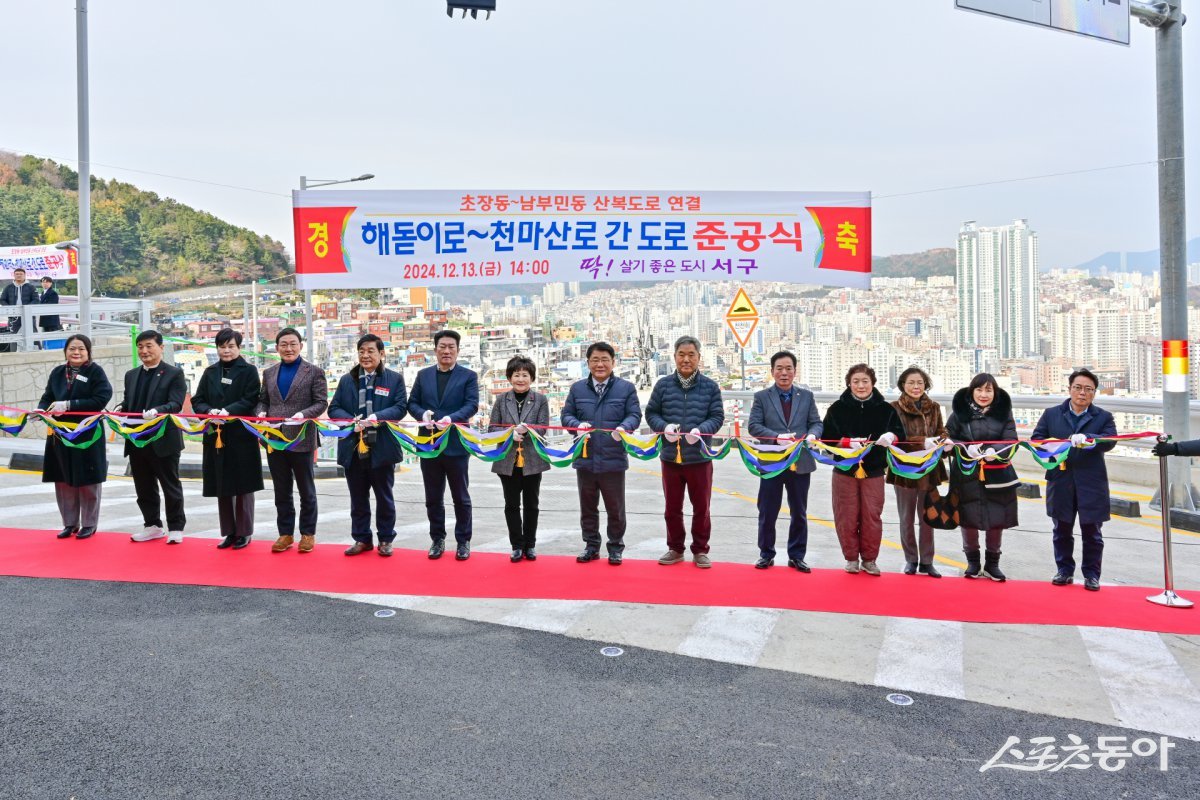 지난 13일 부산 서구 남부민동과 초장동을 잇는 해돋이로-천마산로 간 도로개설 공사 준공식이 열린 가운데 관계자들이 기념촬영을 하고 있다. (사진제공=부산 서구)