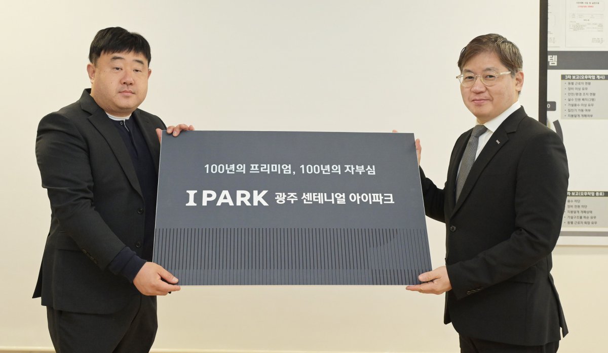 최익훈 HDC현대산업개발 대표이사(오른쪽)가 이승엽 광주 센테니얼 아이파크 예비입주자협의회 대표에게 새로운 단지명을 전달한 뒤 포즈를 취하고 있다. 사진제공 | HDC현대산업개발