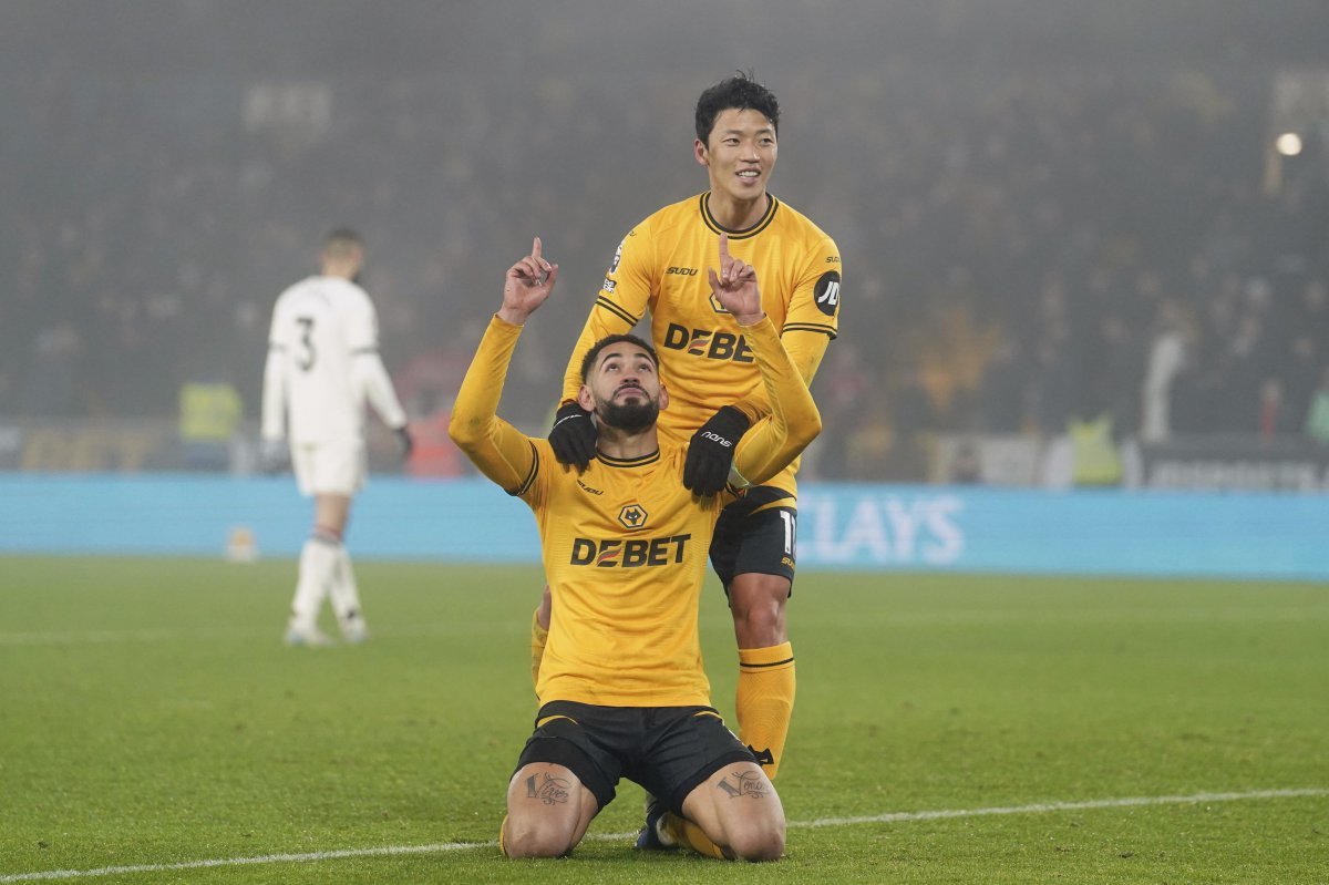 Wolverhampton Wanderers‘ Matheus Cunha, front, celebrates after Hwang Hee-Chan, top, scored their side’s second goal during the English Premier League soccer match between Wolverhampton Wanderers and Manchester United at the Molineux Stadium, Wolverhampton, England, Thursday, Dec. 26, 2024. (David Davies/PA via AP)