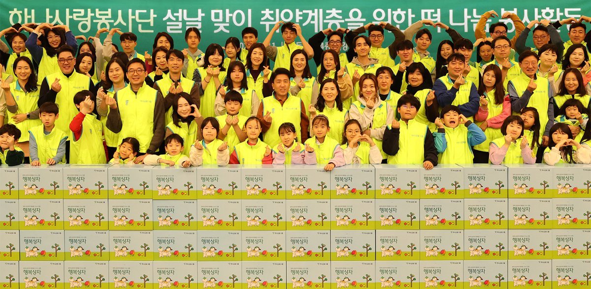 ‘설맞이 전통 떡 나눔 봉사활동’에서 기념 촬영을 하고 있는 함영주 하나금융 회장(두번째 줄 왼쪽에서 다섯 번째). 사진제공｜하나금융 