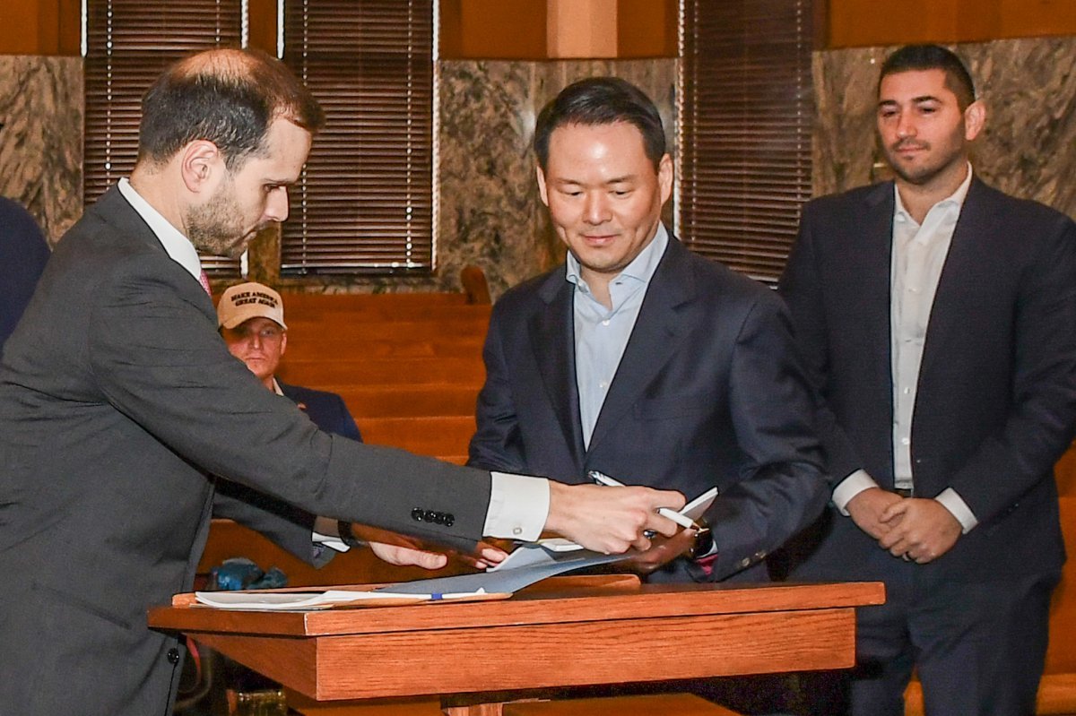 1월 27일(현지시각) 미국 텍사스주 존슨 카운티 지방법원에서 진행된 파리바게뜨 제빵공장 투자 인센티브 조인식에서 허진수 SPC그룹 사장이(가운데) 서명을 하고 있다. 사진제공 |SPC그룹