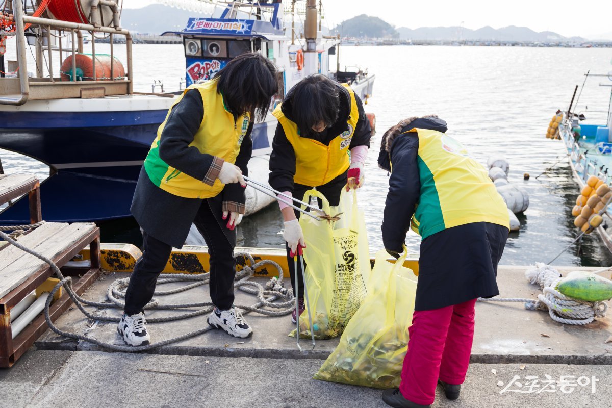 신천지자원봉사단 진해지부가 지난달 25일 속천 유람선 선착장에서 환경 정화 봉사활동 ‘자연아 푸르자’를 진행한 가운데 봉사자들이 부둣가 인근에서 쓰레기를 수거하고 있다. (사진제공=신천지자원봉사단 진해지부)