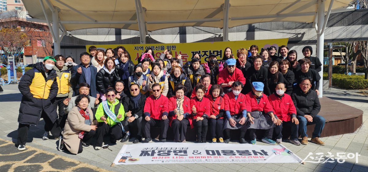 한국미용문화봉사단과 행복드림봉사회 등이 지난 18일 부산진구 연지동에 위치한 ‘초록 나눔의집’ 앞 공원에서 지역 주민 어르신들을 대상으로 ‘짜장면 & 미용봉사’ 나눔 봉사활동을 펼친 가운데 관계자들이 기념촬영을 하고 있다.