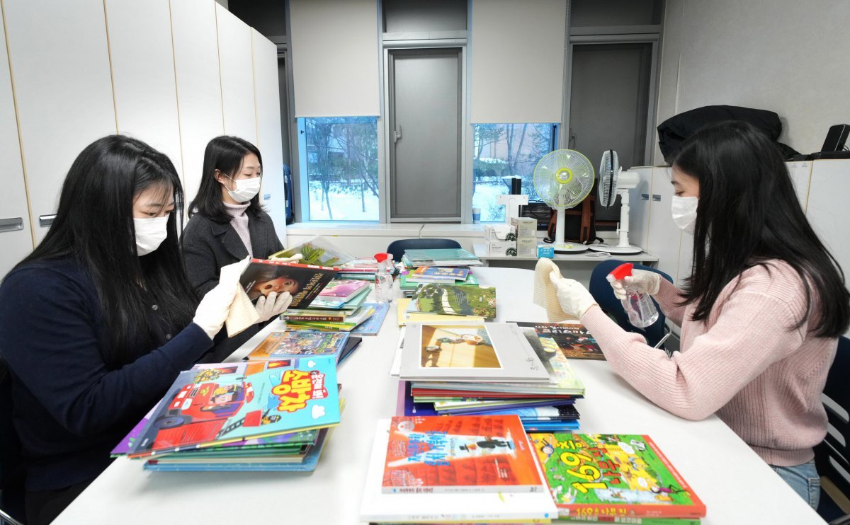 서울의료원 소아청소년과에서 소아 환자를 위한 동화책을 소독하고 있는 팸퍼스 임직원들.사진제공|한국P&G