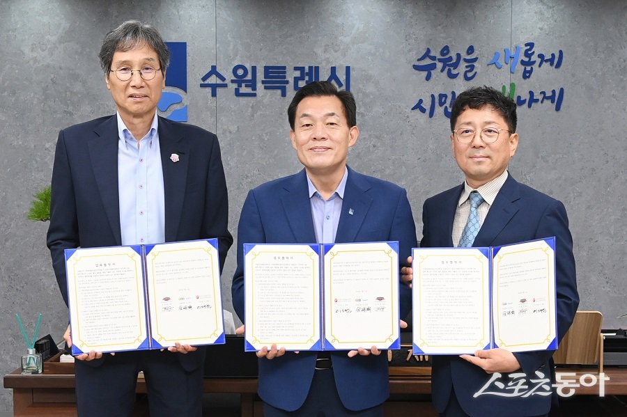 지난해 7월 이재준 수원시장(가운데, 수원시자원봉사센터 이사장)과 최순호 수원FC 단장, 김상연 수원경제정의실천시민연합 공동대표가 새벽빛 장애인 야학 지원을 위한 업무협약 후 기념촬영을 하고 있다. 사진제공|수원시청