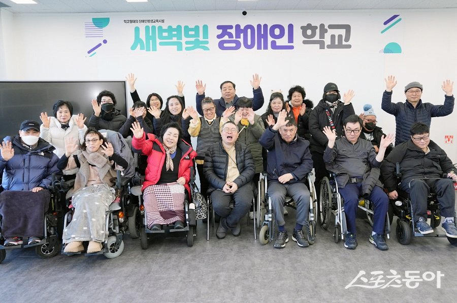 수원시민의 도움으로 새 학습공간을 마련한 새벽빛 장애인학교 학생과 교직원들이 교실에서 기념촬영을 하고 있다. 사진제공|수원시청