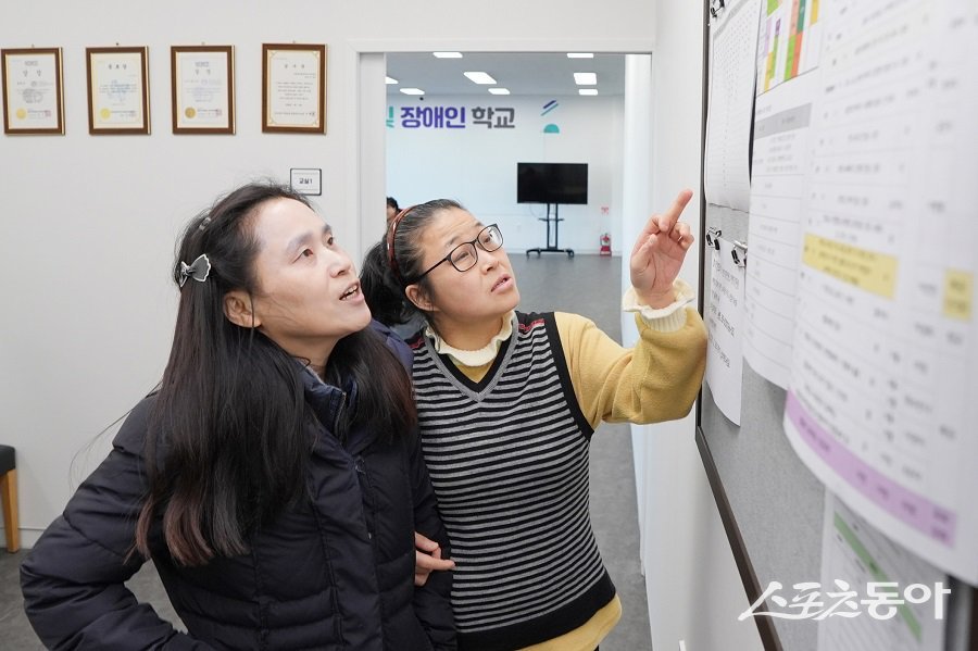 새벽빛 장애인학교 학생들이 새학기 수강신청을 위해 게시판을 보고 상의하고 있다. 사진제공|수원시청