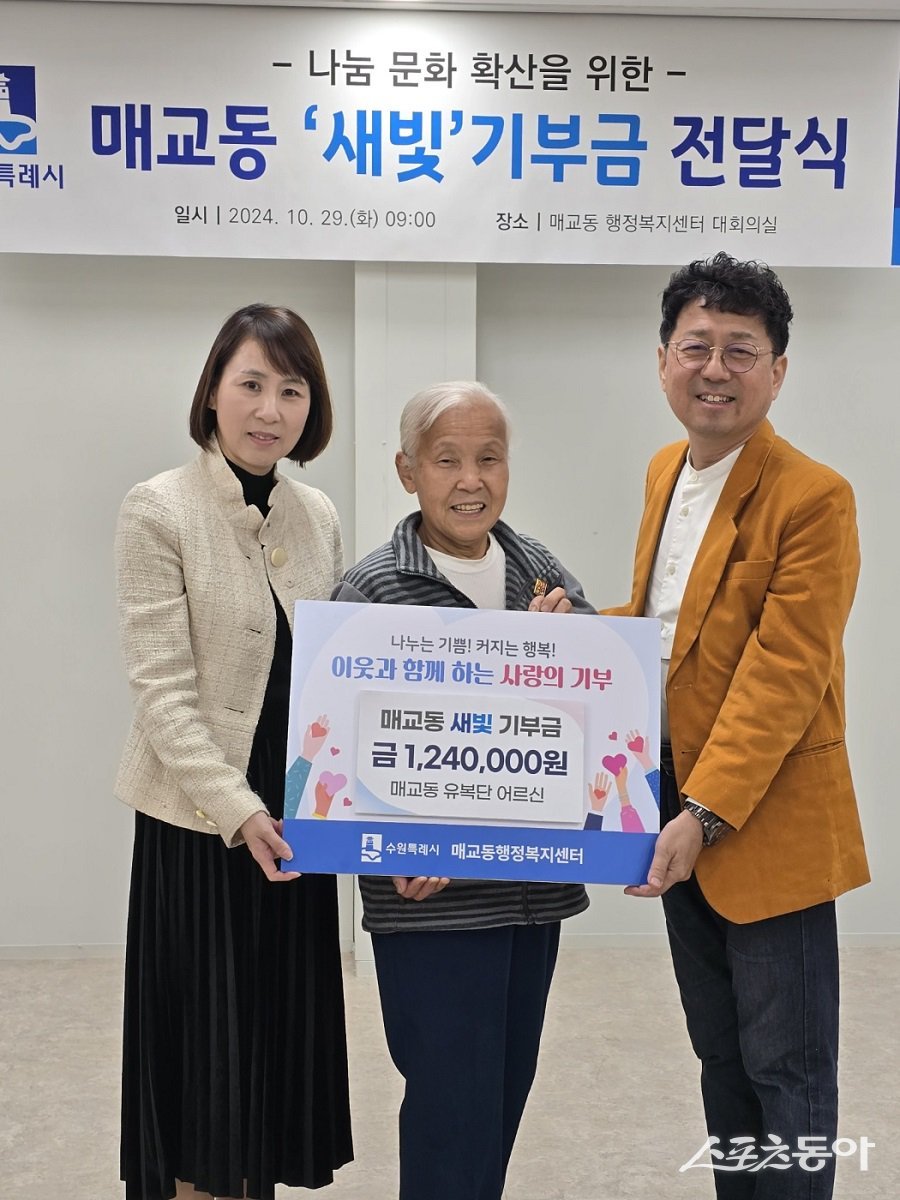 매교동 주민인 유복단 할머니(가운데)가 폐지를 팔아 모은 금액을 새벽빛 장애인학교 이전을 위해 기부하고 있다. 사진제공|수원시청