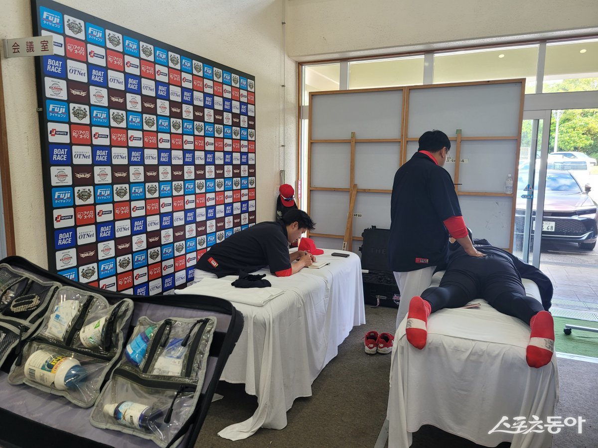 KIA 트레이닝파트가 27일 일본 오키나와 킨구장에서 열린 LG 트윈스와 연습경기를 앞두고 선수들에게 맞춤식 몸 관리를 진행하는 모습. 선수 개개인의 몸 상태를 정확하게 파악해 메모하고, 보강치료도 함께 병행하고 있다. 오키나와(일본)|장은상 기자 award@donga.com