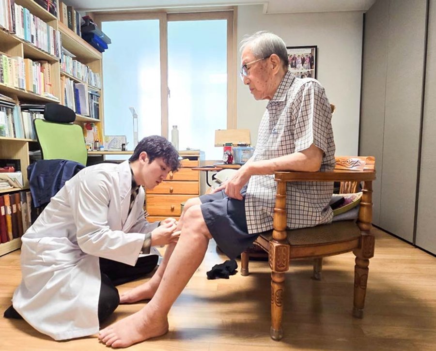자생의료재단 의료진이 독립유공자 김영관 애국지사 자택에 방문해 무릎 관절을 진료하고 있다 사진제공|자생한방병원