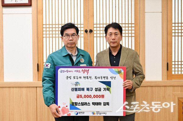 포항스틸러스 박태하 감독(오른쪽)이 김광열 영덕군수에게 산불피해 복구 성금을 전달하고 있다. 사진제공 ㅣ 영덕군
