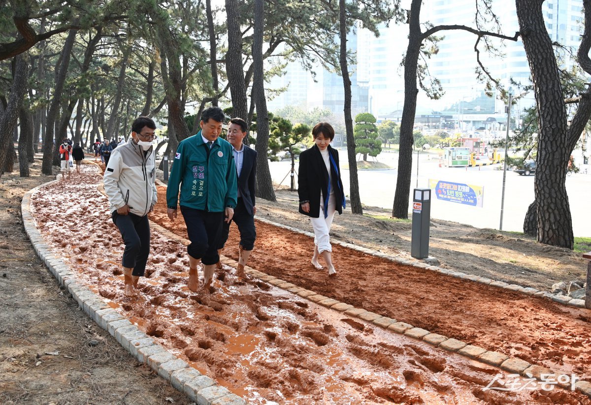 부산 해운대구가 지난 4일 오후 4시 ‘해운대 바다 황톳길’ 준공식을 개최한 가운데 김성수 구청장(왼쪽 두 번째)이 황톳길 체험을 하고 있다. (사진제공=부산 해운대구)