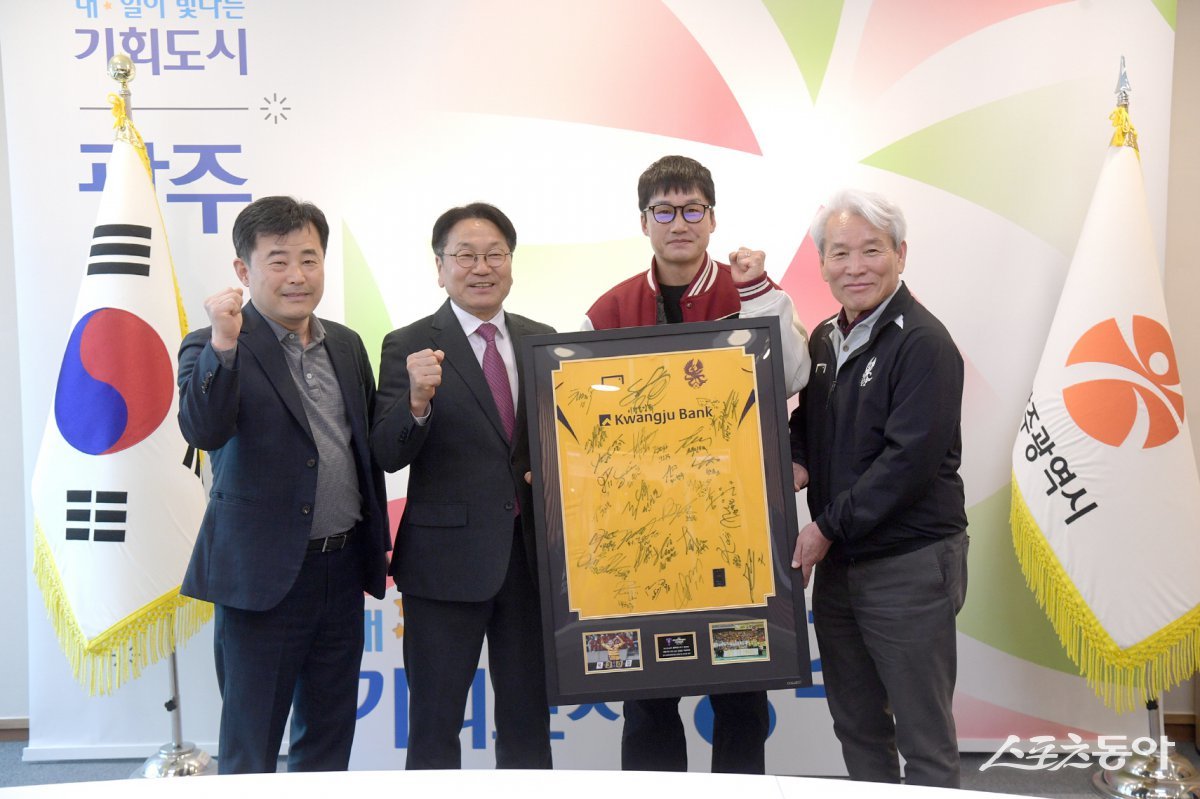 강기정 광주광역시장이 지난 14일 시청 접견실에서 광주FC 선수들의 선전 의지를 담은 선수단 사인 유니폼 액자를 이정효 감독으로부터 전달받고 있다. 사진제공=광주광역시