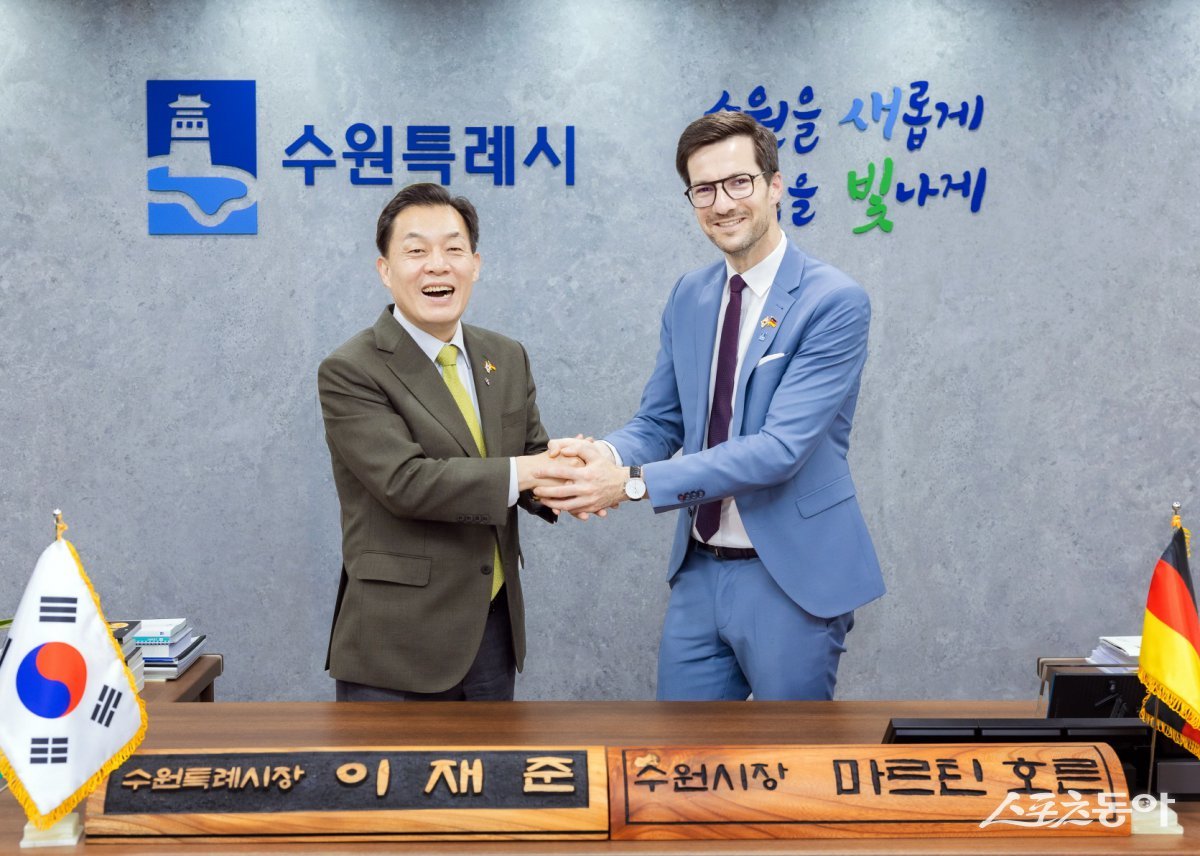 이재준 수원시장이 마르틴 호른 프라이부르크시장에게 명예 수원시장 명패를 전달한 후 활짝 웃고 있다. 사진제공|수원시