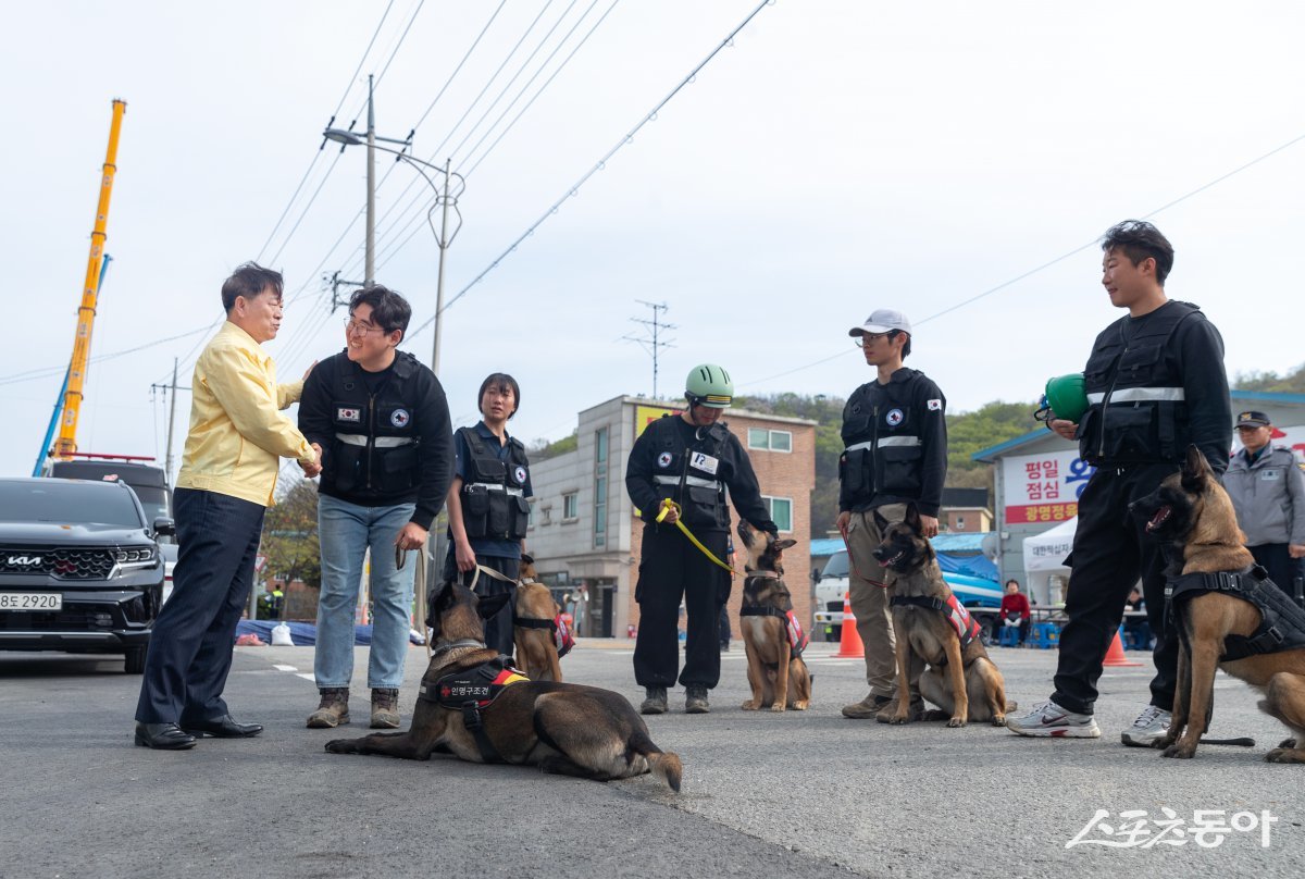 박승원 광명시장이 지난 16일 오후 신안산선 공사현장 붕괴사고 실종자 수색에 큰 역할을 한 (사)한국인명구조견협회 대원들을 격려하고 있다. 사진제공|광명시