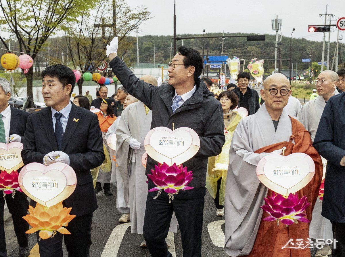 정명근 화성특례시장이 연등음악 축제에 참석해 시민들에게 인사하고 있다(왼쪽 배정수 화성특례시 의장, 가운데 정명근 화성특례시장, 오른쪽 용주사 주지 성효스님). 사진제공|화성시