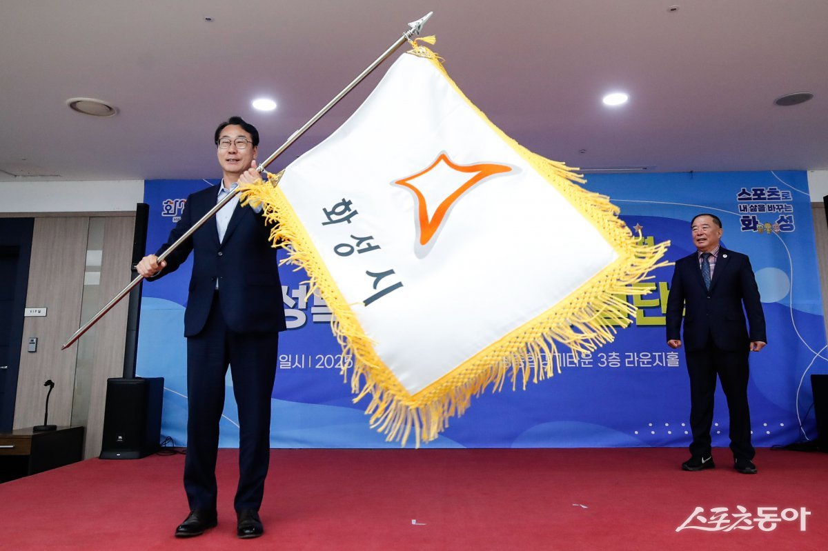 정명근 화성특례시장이 경기도체육대회 선수단에 전달하기에 앞서 화성시 깃발을 흔들고 있다. 사진제공|화성시