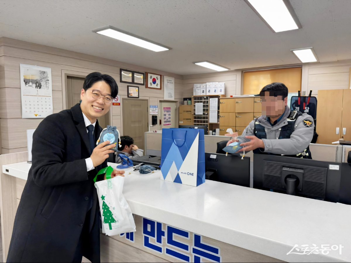 신천지 부산교회가 지난 1월 설 연휴를 앞두고 성전 주변 상가를 돌며 ‘설 이벤트’ 행사를 진행한 가운데 홍보부 관계자가 인근 파출소에 선물 전달 후 기념촬영을 하고 있다. (사진제공=신천지예수교 부산야고보지파)