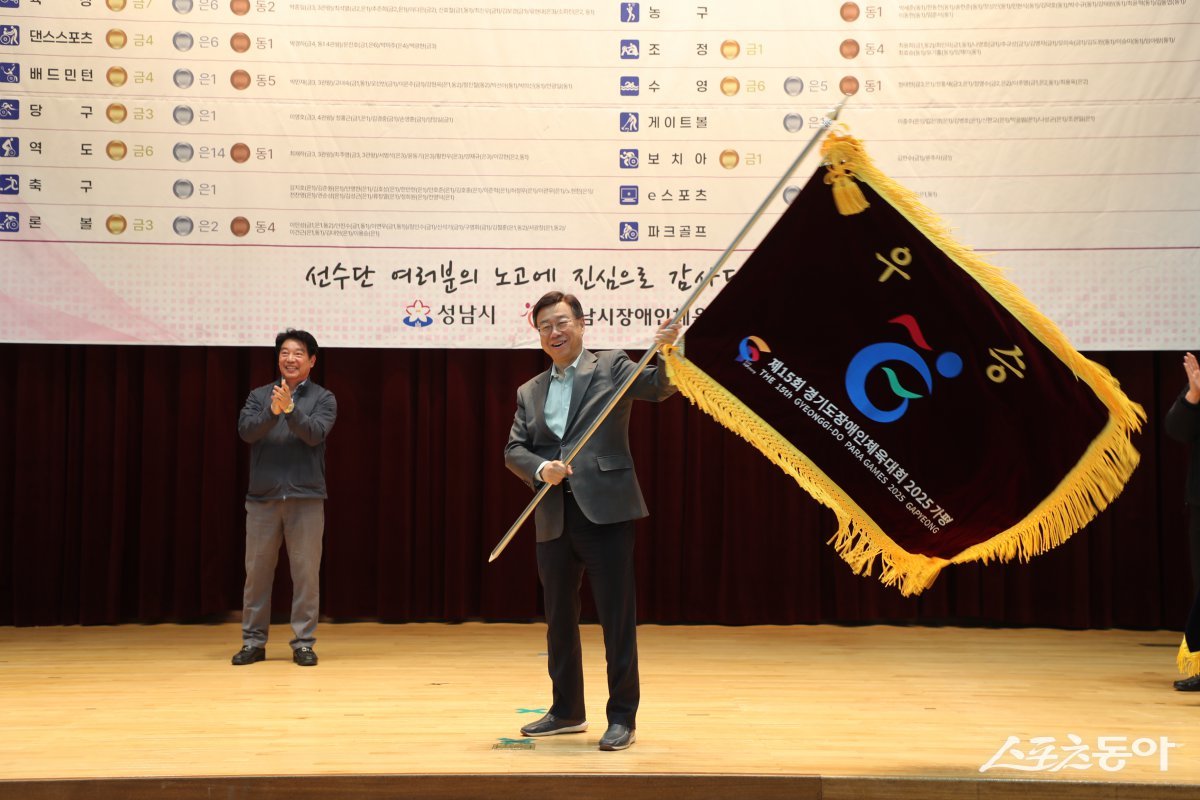 신상진 성남시장이 29일 성남종합스포츠센터에서 제15회 경기도장애인체육대회 출전선수단 해단식에 참석해 우승기를 흔들고 있다. 사진제공ㅣ성남시