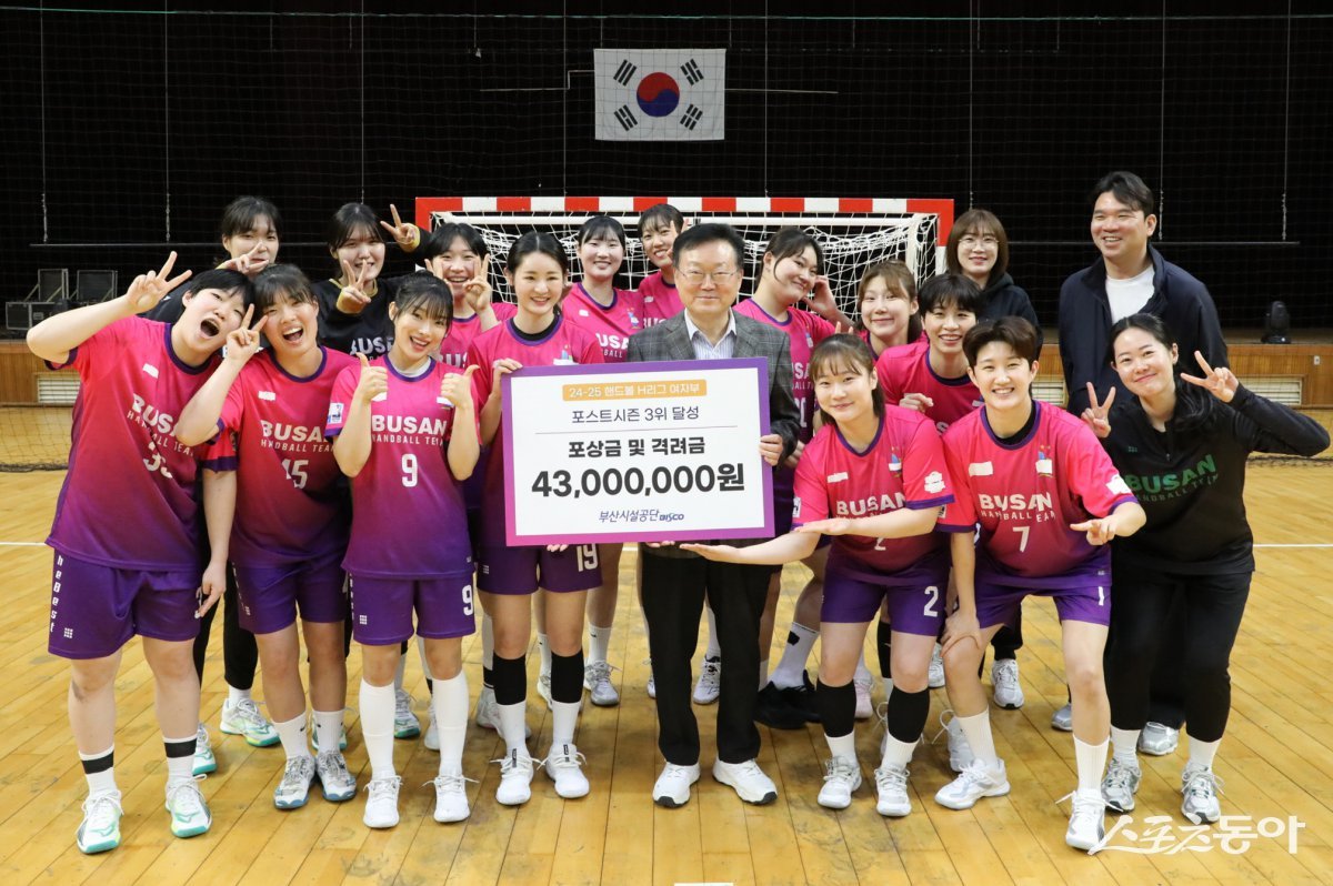 이성림 이사장(가운제)이 여자핸드볼선수단에 포상금 및 격려금을 전달하고 기념촬영을 하고 있다. (사진제공=부산시설공단)