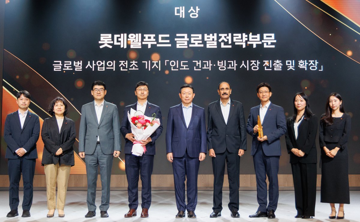 롯데어워즈 대상을 수상한 롯데웰푸드 글로벌전략부문과 기념 촬영을 하고 있는 신동빈 롯데 회장(가운데). 사진제공|롯데