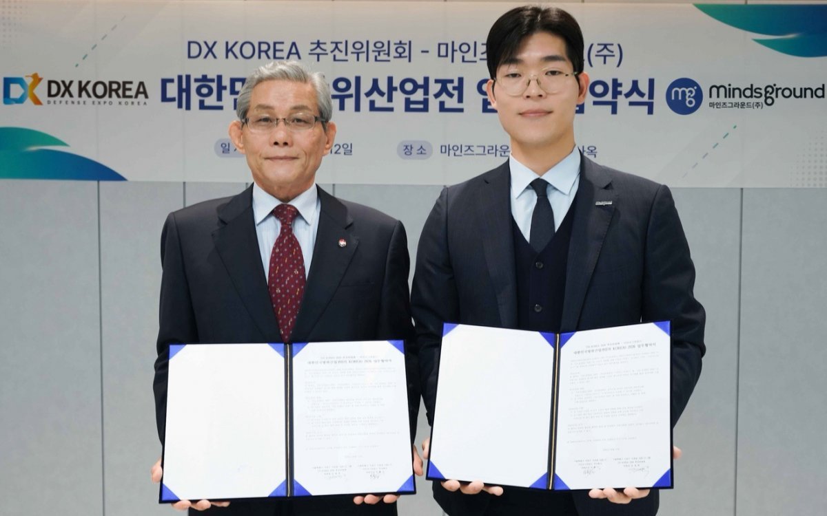 12일, 마인즈그라운드(주) 민환기 대표(오른쪽)와 DX KOREA 2026 김영후 추진위원장이 대한민국 방위산업전(DX KOREA) 2026 업무협약을 체결한 뒤 기념촬영을 하고 있다.