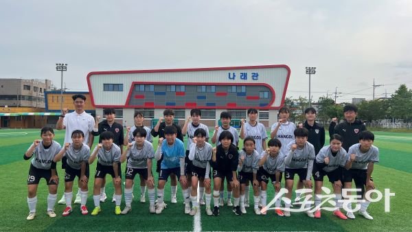 포항항도중학교 여자 축구부와 김영복 감독(우측 윗줄)이 지난 16일 포항상대초등학교에서 연습 경기를 하기 전 파이팅을 하고 있다. 사진제공|정다원 기자