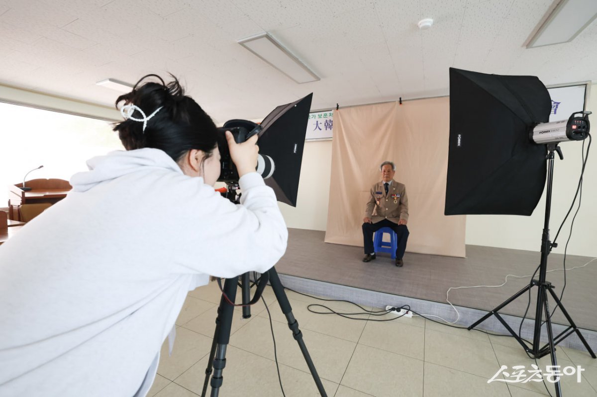 신천지자원봉사단 부산서부지부가 ‘영원히 빛날 평화의 영웅’ 활동을 진행한 가운데 사진작가가 국가 유공자 어르신을 촬영하고 있다. (사진제공=신천지자원봉사단 부산서부지부)