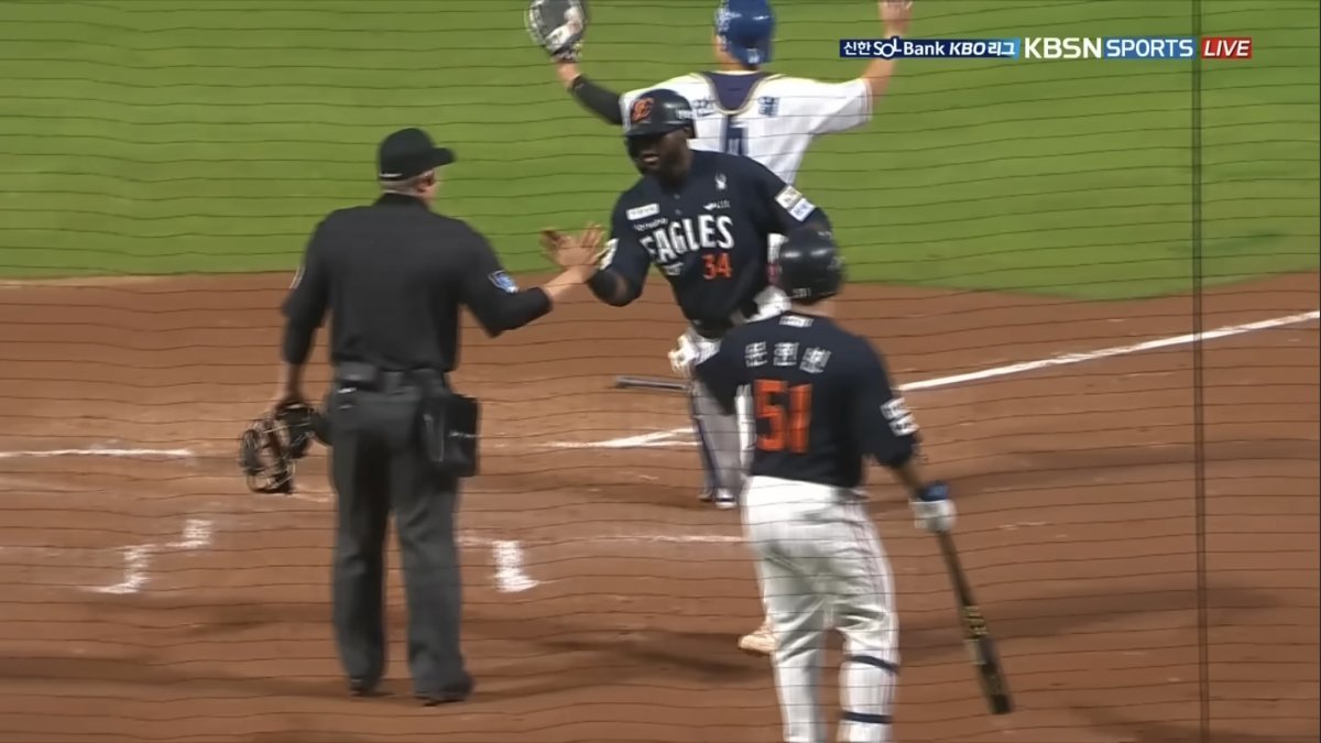 한화 외국인타자 에스테반 플로리얼(34번)이 지난달 30일 창원NC파크에서 열린 NC와 원정경기 5회초 득점한 뒤 정종수 심판위원(왼쪽)을 동료로 착각해 손뼉을 마주치고 있다. 사진출처|티빙 중계화면 캡처