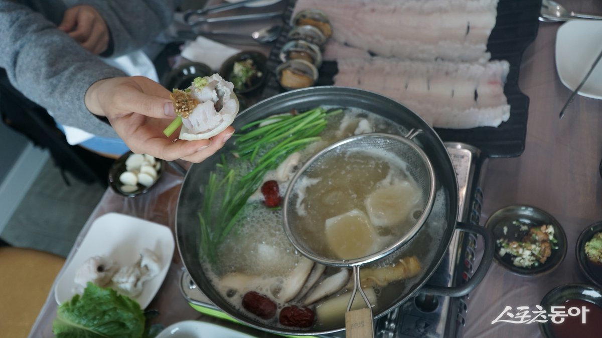 끓는 육수에 살짝 데쳐 양파 위에 올린 갯장어 샤부샤부. 억센 뼈가 먹는데 걸리지 않도록 잔칼질을 한 덕분에 육수에 넣으면 하얗게 핀 꽃처럼 변한다 장흥|김재범 기자 oldfield@donga.com