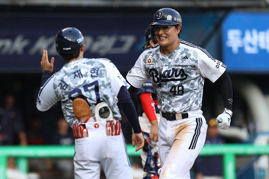 두산 김동준(오른쪽)이 6일 잠실구장에서 열린 롯데와 홈경기 6회말 우월 솔로포로 데뷔 첫 홈런을 신고한 뒤 김재현 코치와 기쁨을 나누고 있다. 사진제공|두산 베어스