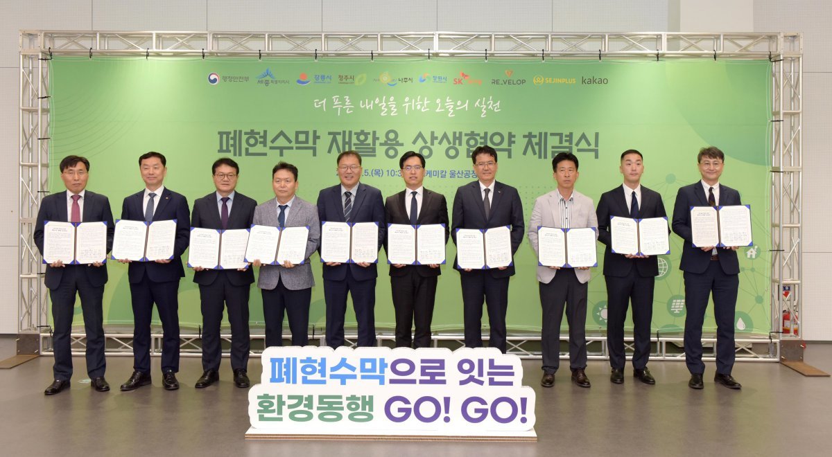 SK케미칼이 행정안전부, 5개 지자체와 함께 폐현수막 자원 선순환 체계 구축에 나선다. 김현석 SK케미칼 리사이클사업본부장(오른쪽에서 네번째), 김민재 행정안전부 차관보(오른쪽에서 다섯번째) 등이 체결식을 마치고 기념사진을 촬영하고 있다. 사진제공｜SK케미칼