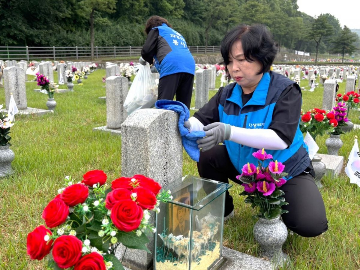 자생의료재단 임직원과 봉사단이 국립서울현충원을 찾아 묘석을 닦고 있다    사진제공｜자생의료재단