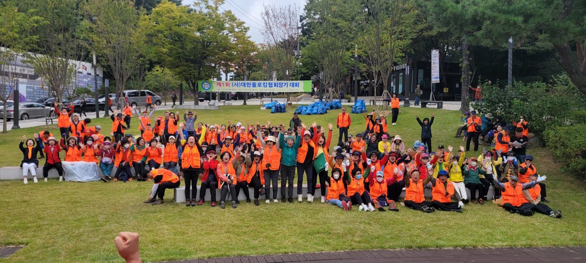 지난해 10월 서울 광진구 아차산에서 열린 제1회 (사)대한플로킹협회장기대회에서 참가 회원들이 파이팅을 외치고 있다. 회원들 뒤에 쓰레기를 수거한 봉투들이 놓여있다. 대한플로킹협회는 회원 확장을 통해 건강과 환경보호 두 마리 토끼를 잡고 있다. 사진제공 ㅣ 대한플로킹협회
