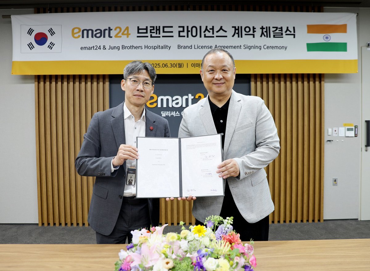 인도 진출을 위한 브랜드 라이선스 계약 체결 후 기념 촬영을 하고 있는 최진일 이마트24 대표(왼쪽)와 인도 시장 1세대 한인 사업가 피터 정. 사진제공｜이마트24