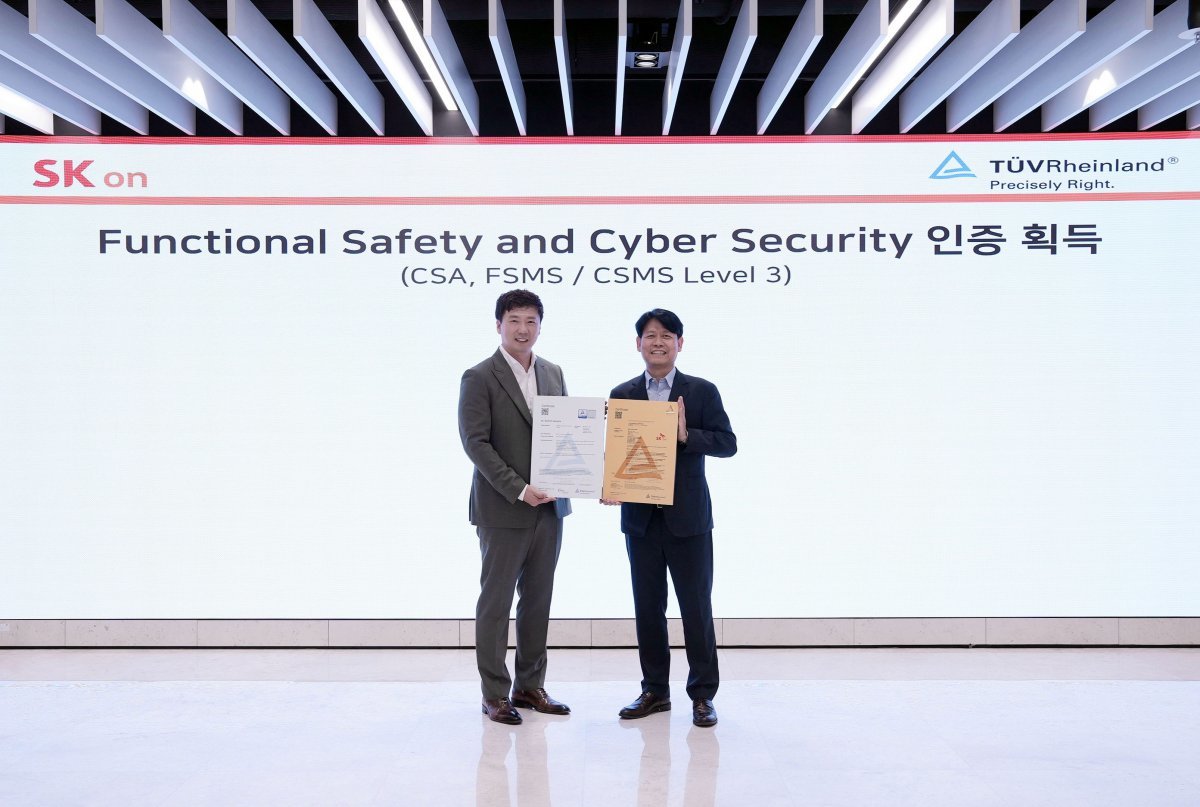 박기수 SK온 연구개발(R&D) 본부장(우측)과 노진표 TUV라인란드 코리아 기능 안전 및 사이버 보안 아시아 총괄 이사(좌측)가 대전 SK온 배터리 연구원에서 사이버 보안 인증(CSA) 등 국제 인증 수여식 행사 후 기념 촬영하고 있다. 사진제공 ｜SK온