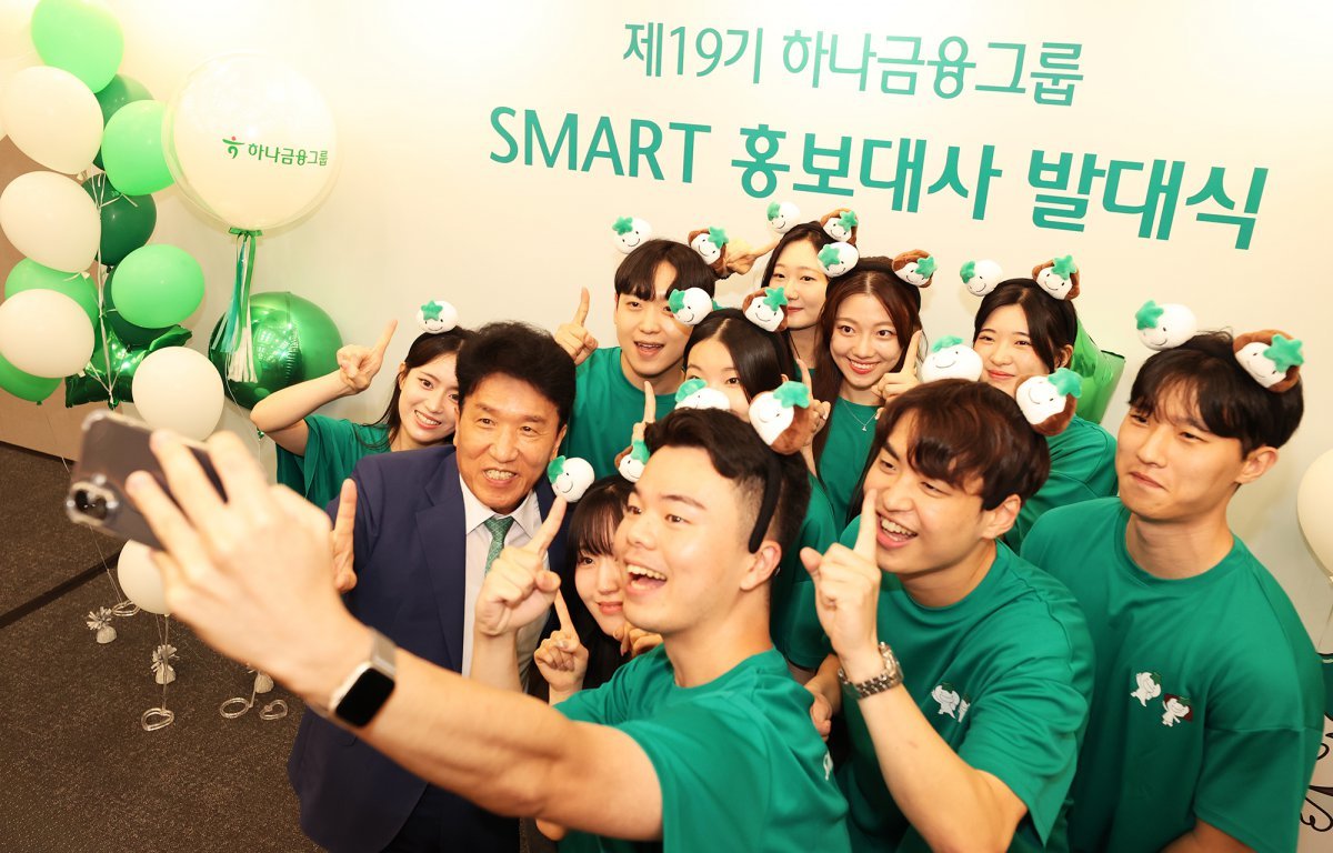 스마트 홍보대사들과 함께 ‘하나’를 의미하는 손가락 포즈를 취하며 기념촬영을 하고 있는 함영주 하나금융 회장(왼쪽에서 두 번째). 사진제공｜하나금융
