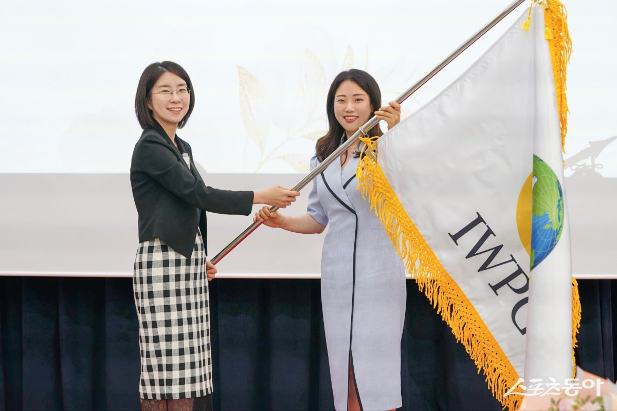 ㈔세계여성평화그룹(IWPG) 전나영 신임 대표(오른쪽)가 윤현숙 전 대표로부터 깃발을 전달받고 있다. (제공: IWPG)