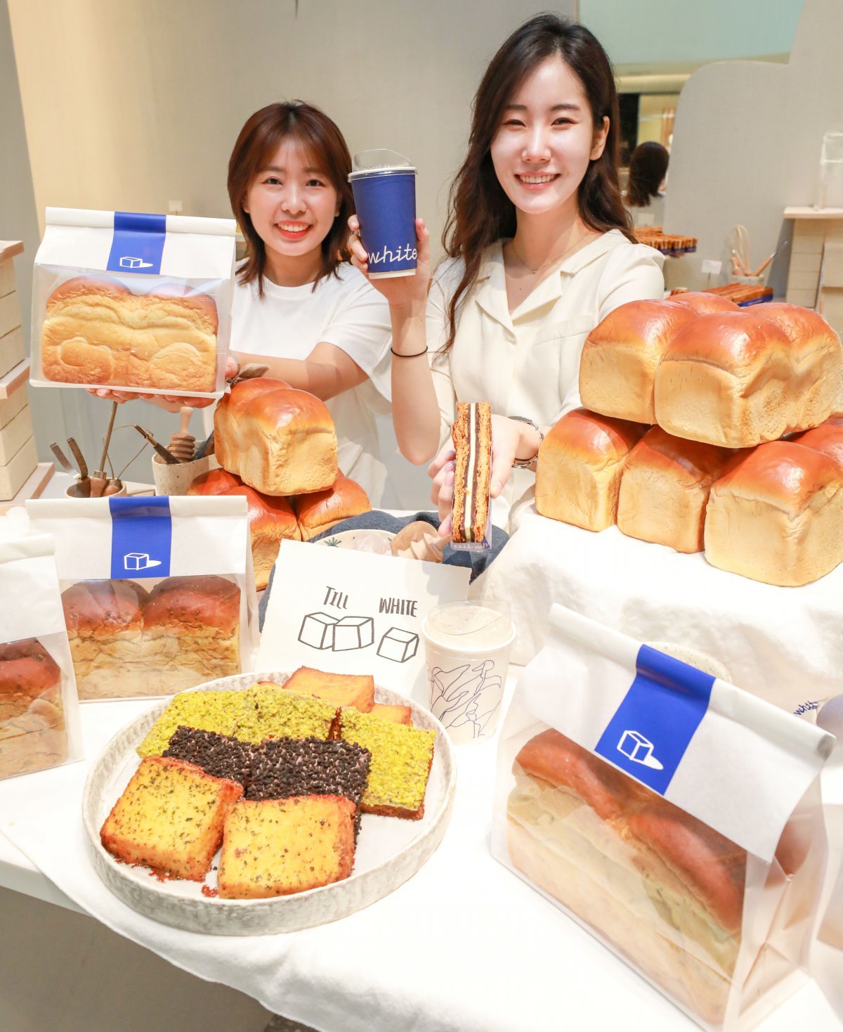 현대백화점이 자체 개발한 F&B(식음료) 카페 브랜드 ‘틸화이트’ 대표 상품을 소개하고 있는 직원들. 사진제공|현대백화점